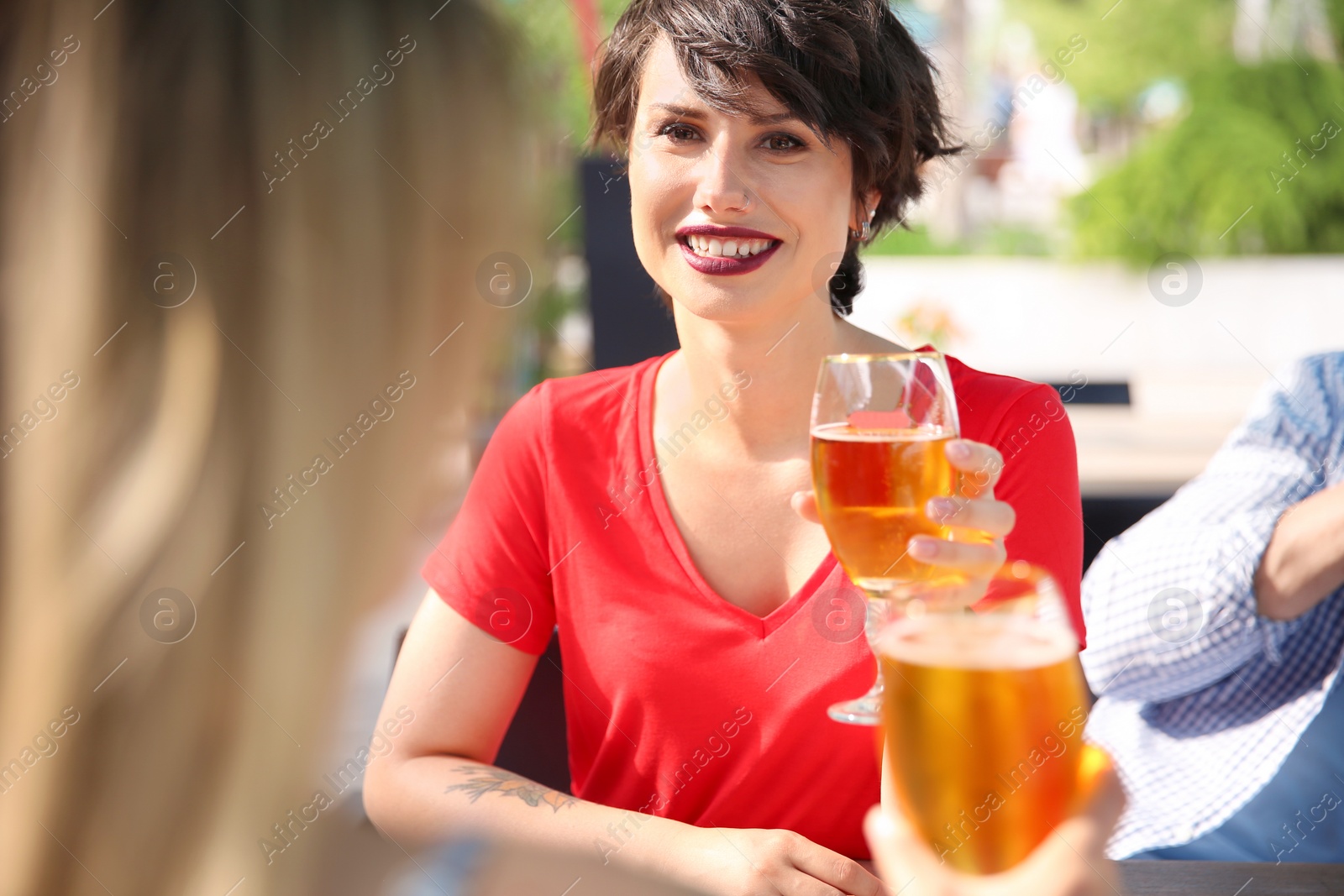Photo of Young women with glasses of cold beer at table