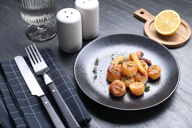 Photo of Delicious fried scallops served on dark gray textured table