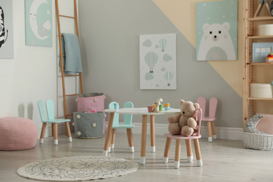 Small table and chairs with bunny ears in children's room interior