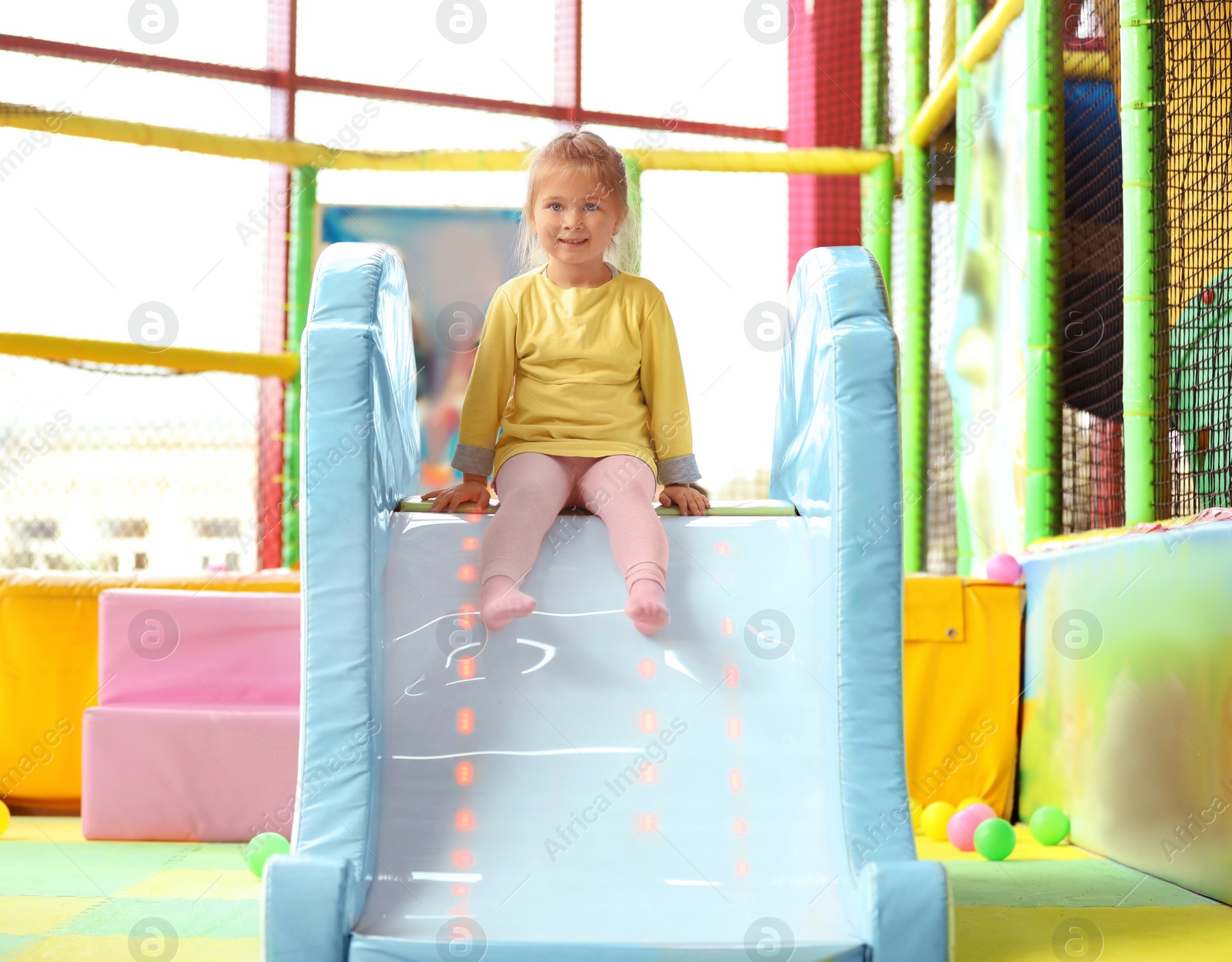 Photo of Cute little child playing at indoor amusement park