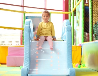 Cute little child playing at indoor amusement park