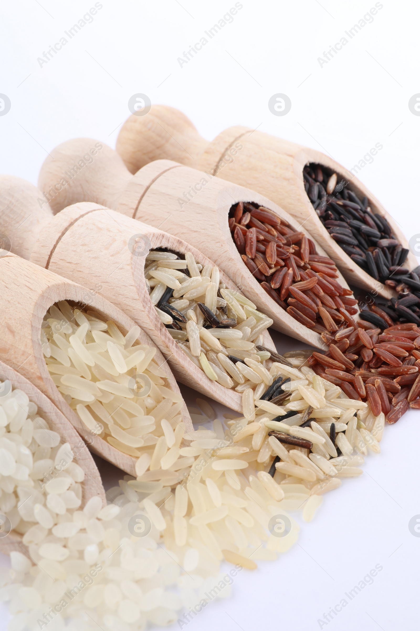 Photo of Different sorts of rice in scoops on white background