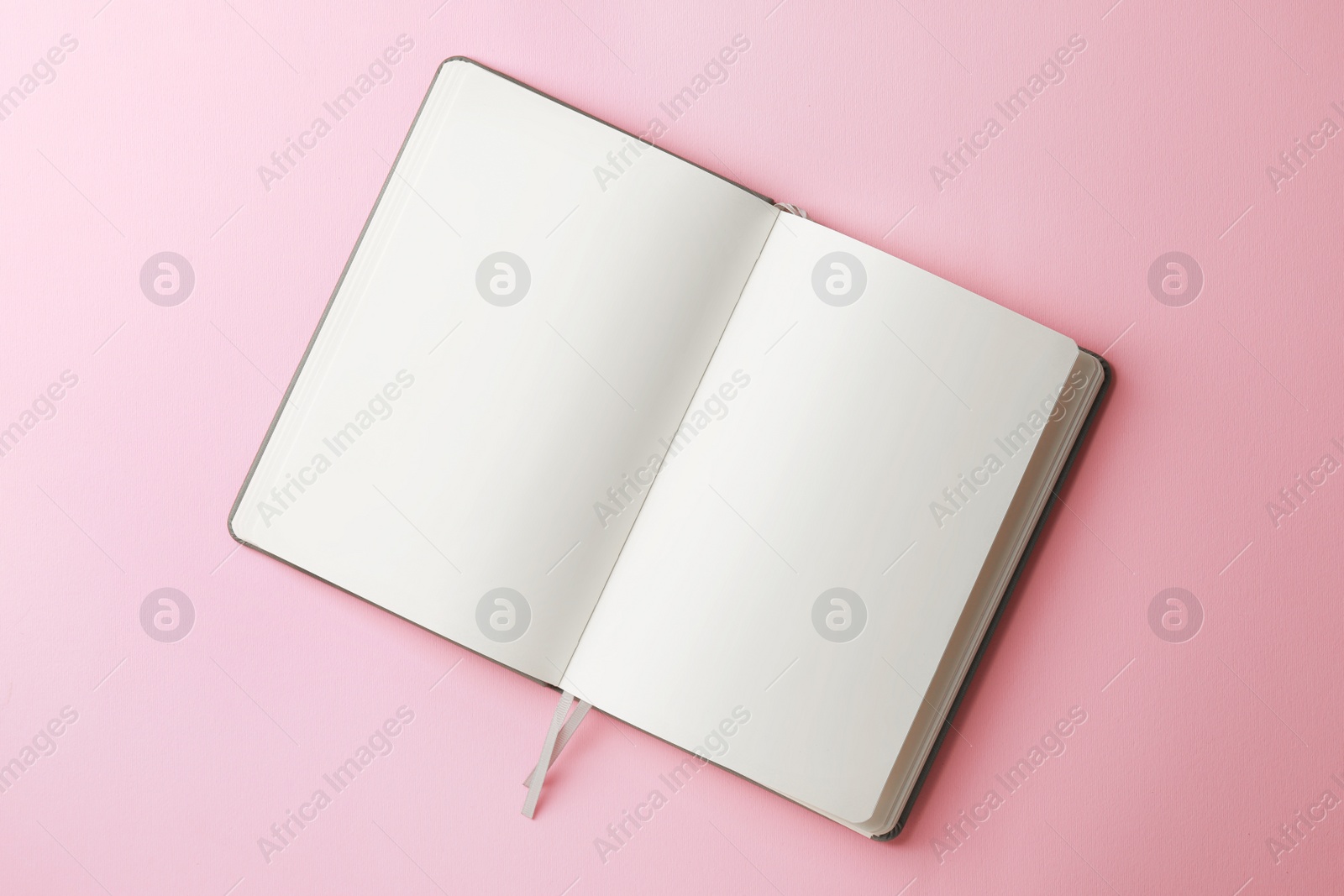 Photo of Blank notebook on pale pink background, top view