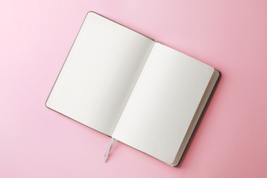 Photo of Blank notebook on pale pink background, top view