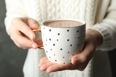 Photo of Woman holding cup of tasty cocoa, closeup