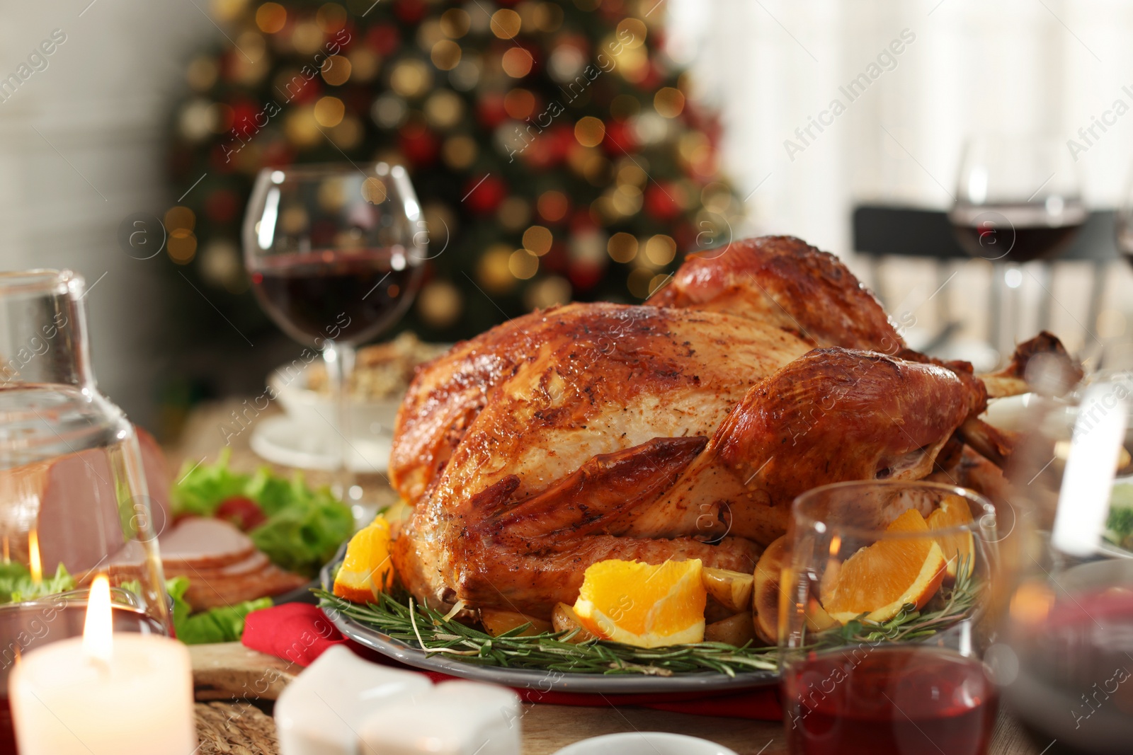 Photo of Festive dinner with delicious baked turkey served on table indoors. Christmas celebration