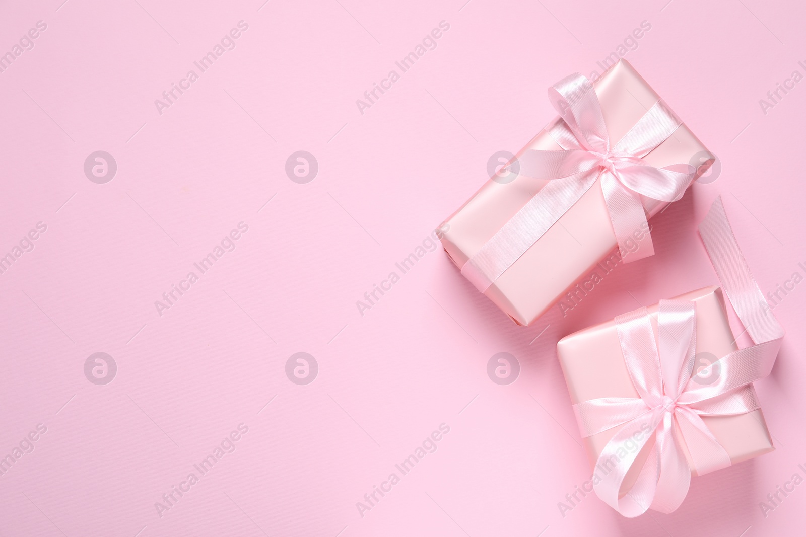 Photo of Beautiful gift boxes on pink background, flat lay. Space for text