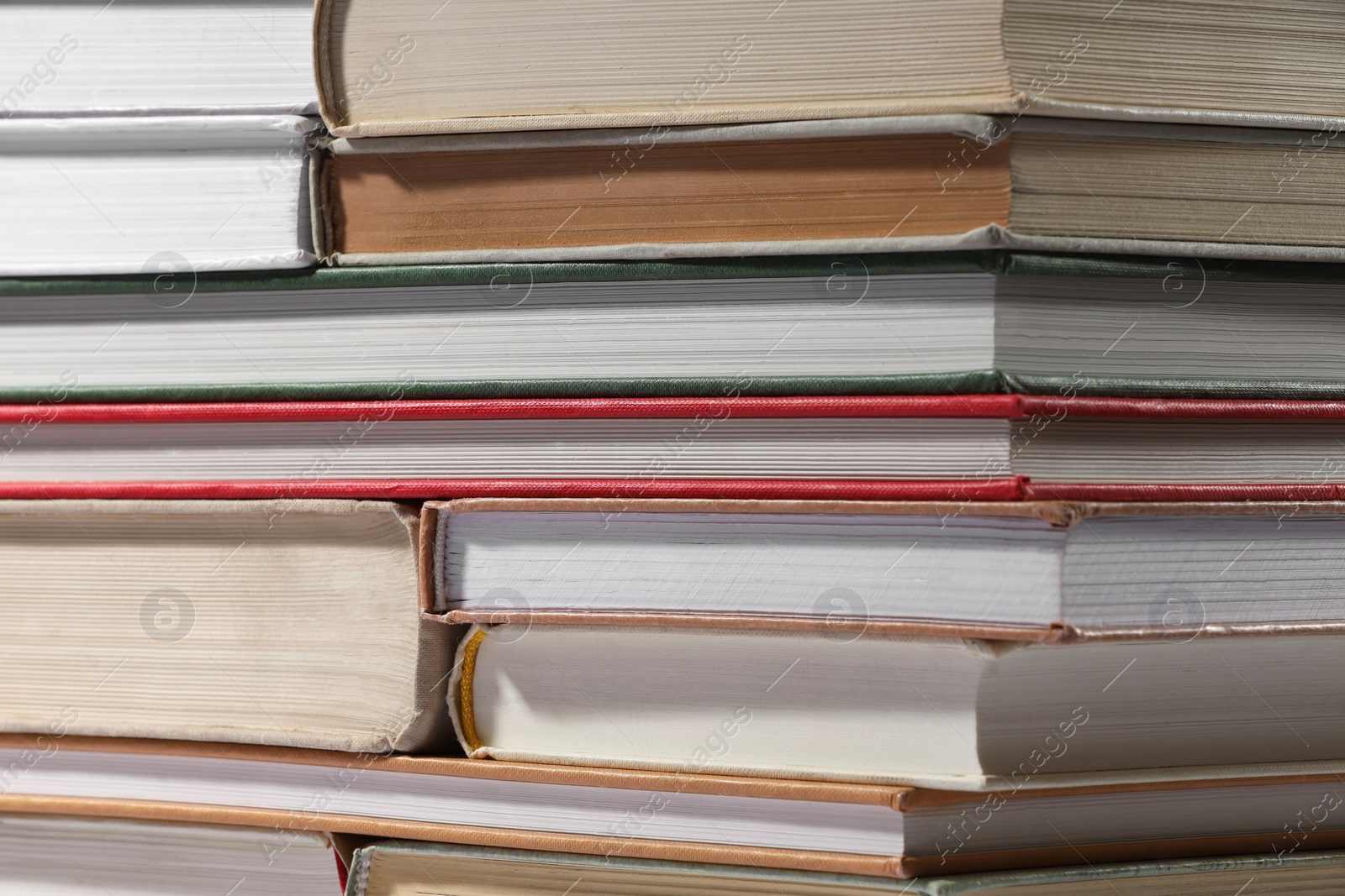 Photo of Stack of many different hardcover books as background, closeup