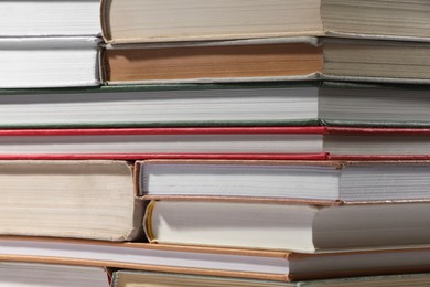 Photo of Stack of many different hardcover books as background, closeup