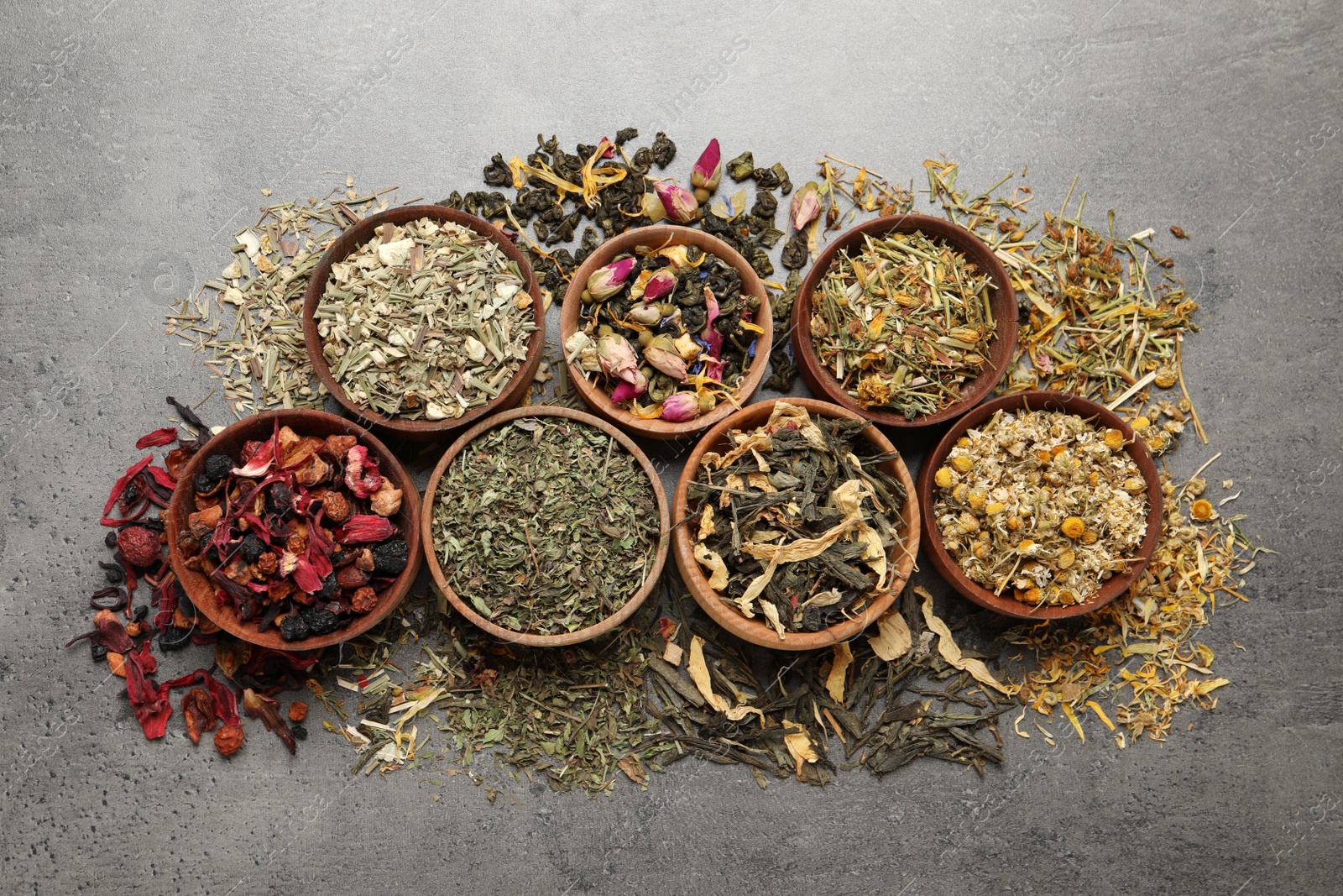 Photo of Flat lay composition with different dry teas on grey table