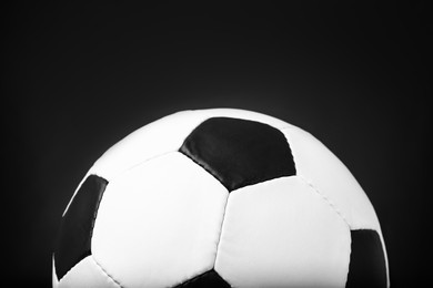 Photo of Leather football ball on black background, closeup