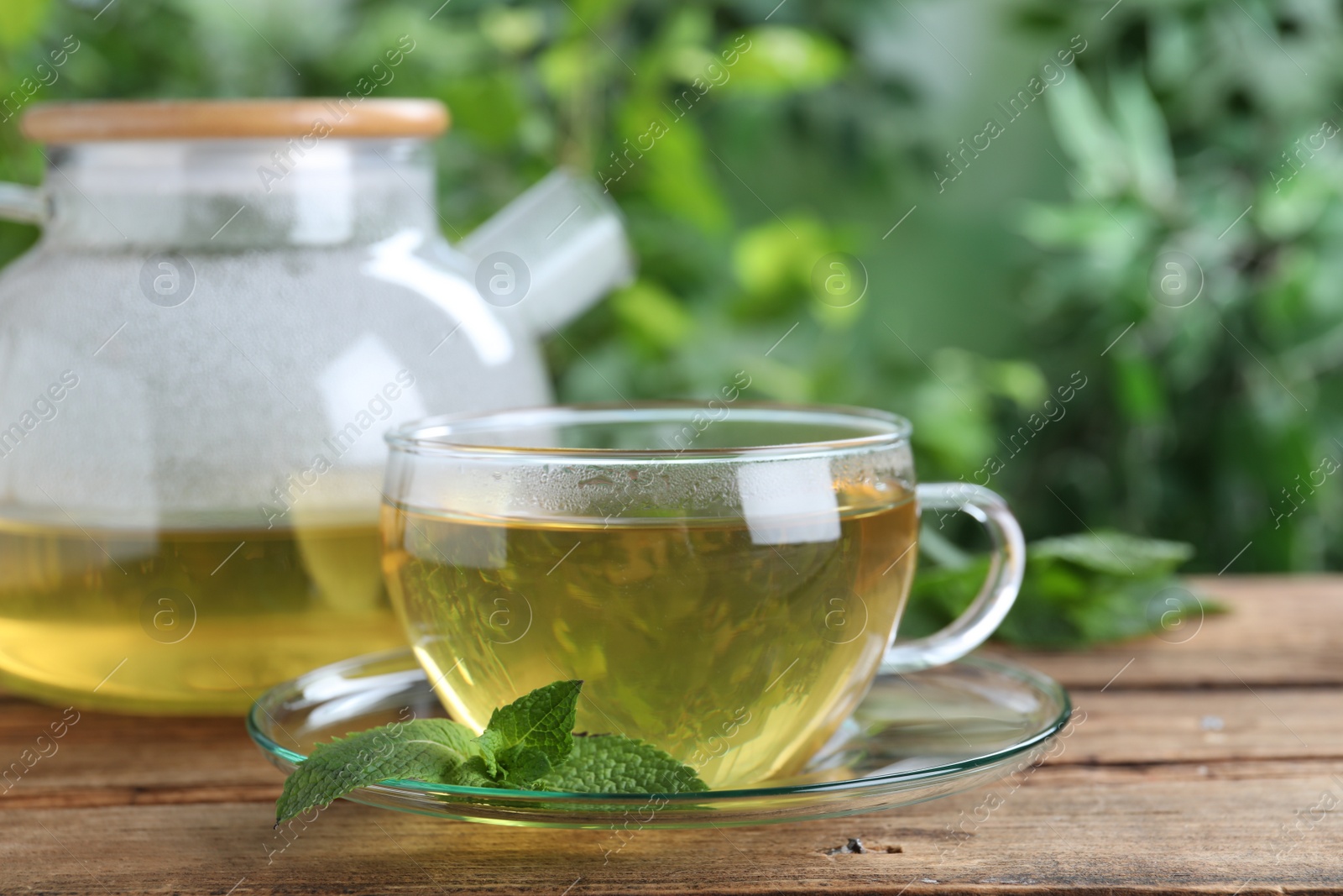 Photo of Fresh green tea with mint on wooden table