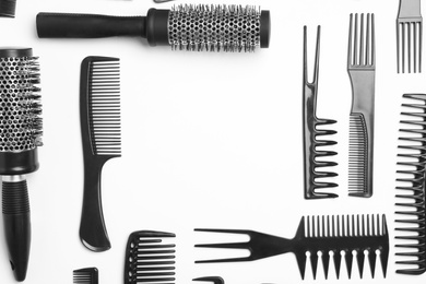 Photo of Frame of hair combs and brushes on white background, top view. Space for text