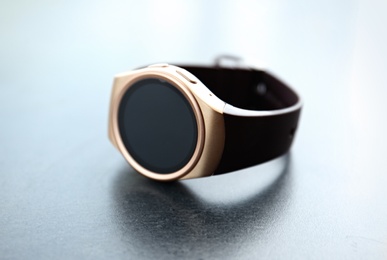 Photo of Modern stylish smart watch on grey table, closeup