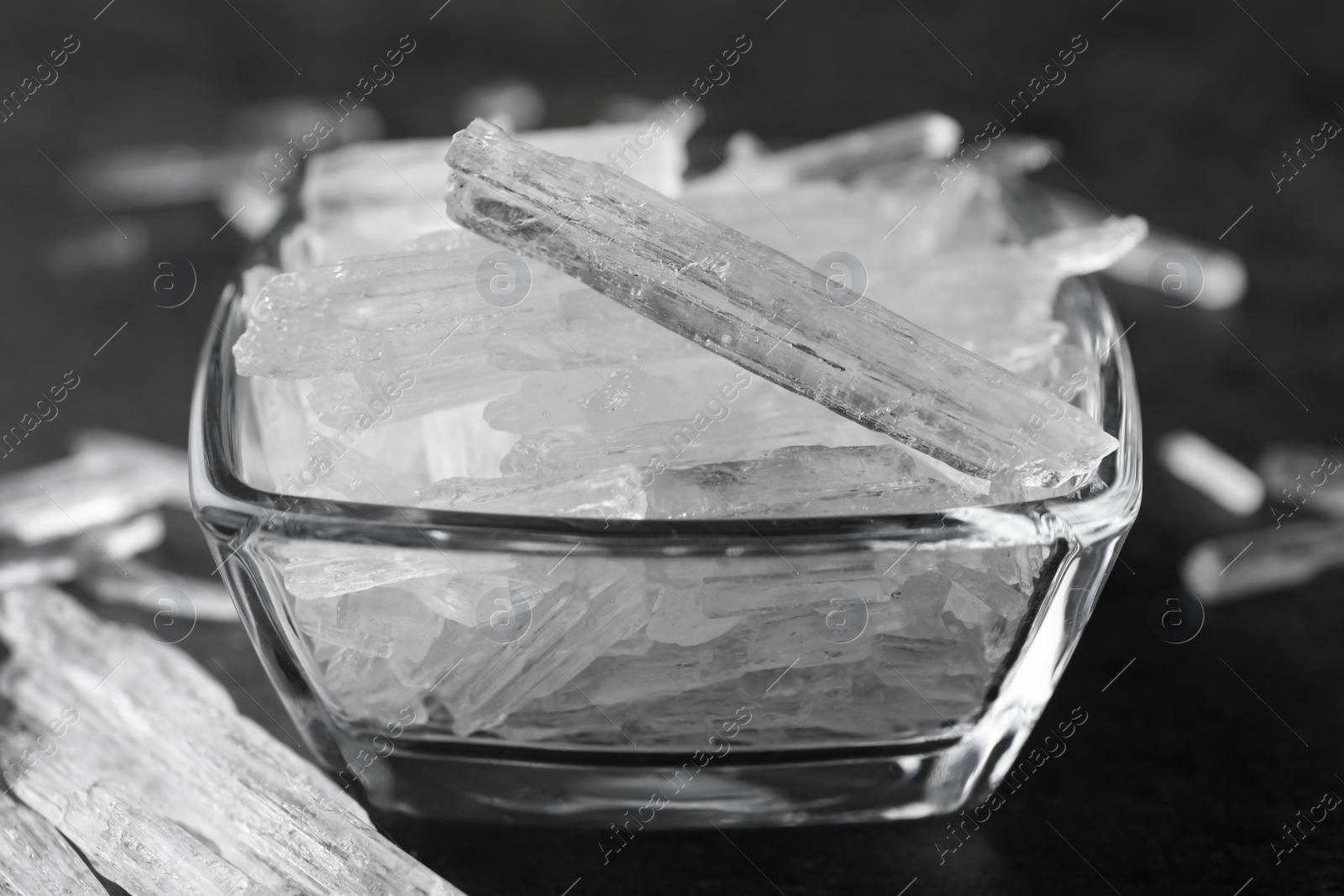 Photo of Menthol crystals in bowl on grey background, closeup