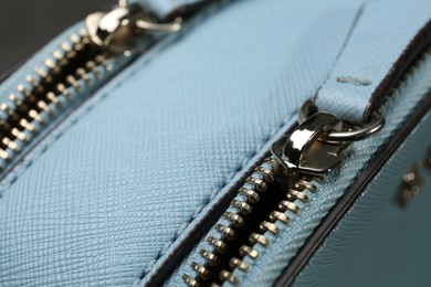 Light blue women's bag with zippers, closeup view