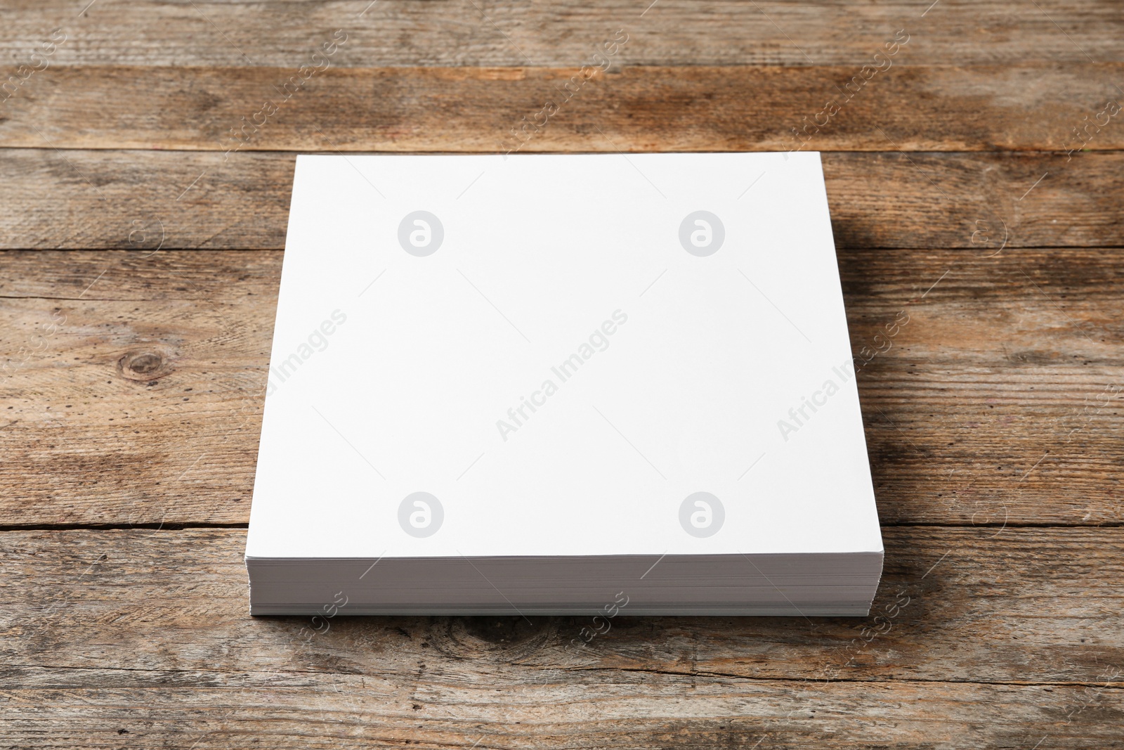 Photo of Stack of blank paper sheets for brochure on wooden background. Mock up