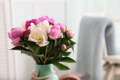 Photo of Vase with bouquet of beautiful peonies in room. Space for text