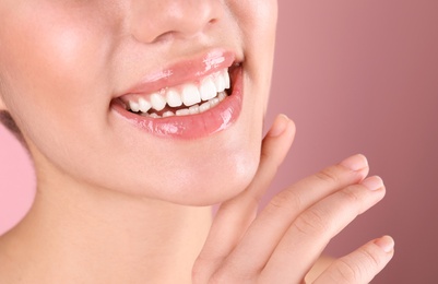 Beautiful young woman with healthy teeth on color background, closeup