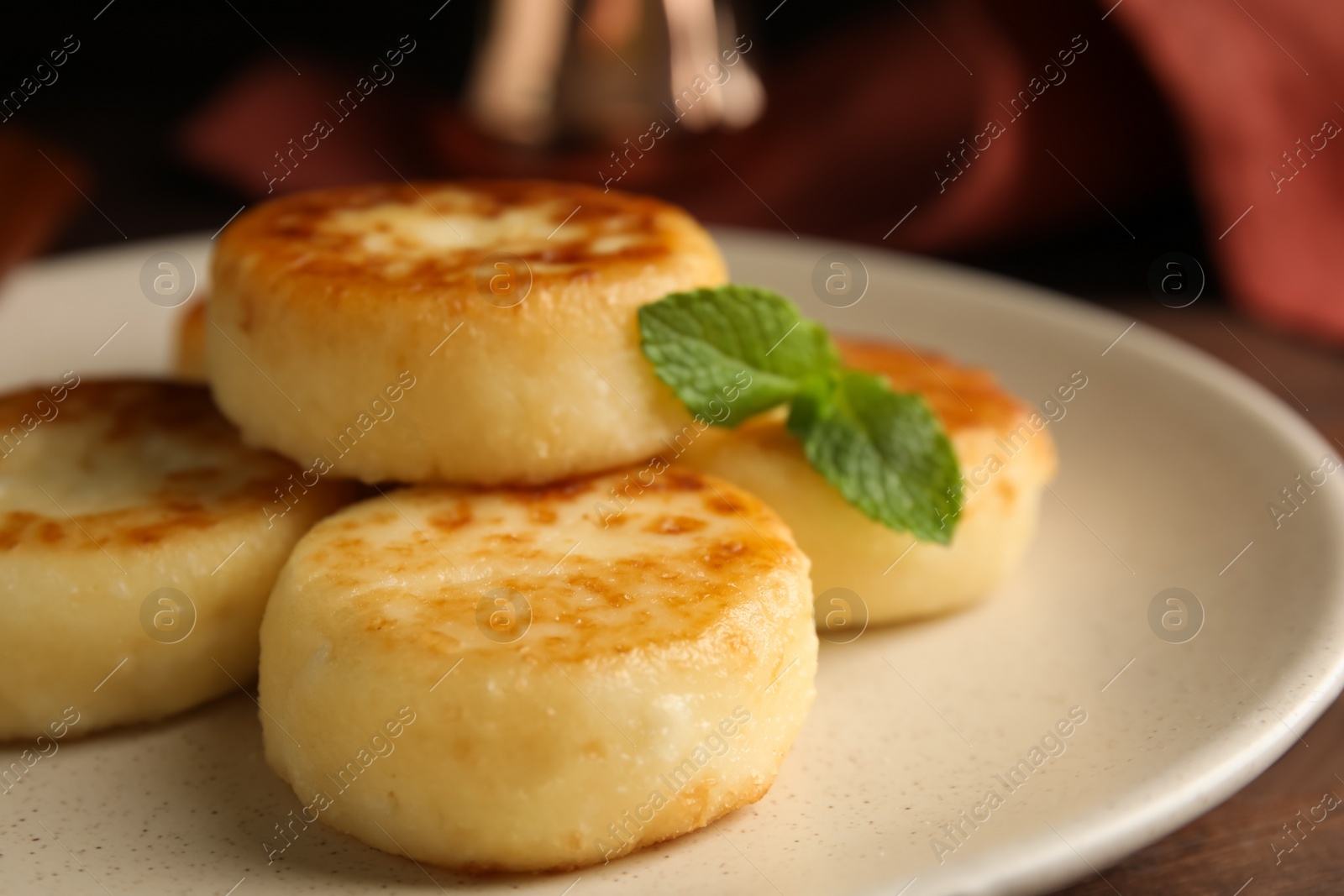 Photo of Delicious cottage cheese pancakes with mint on table, closeup