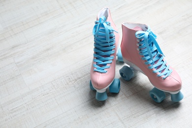 Vintage roller skates on floor indoors. Space for text