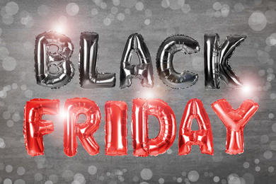 Phrase BLACK FRIDAY made of foil balloon letters on grey background