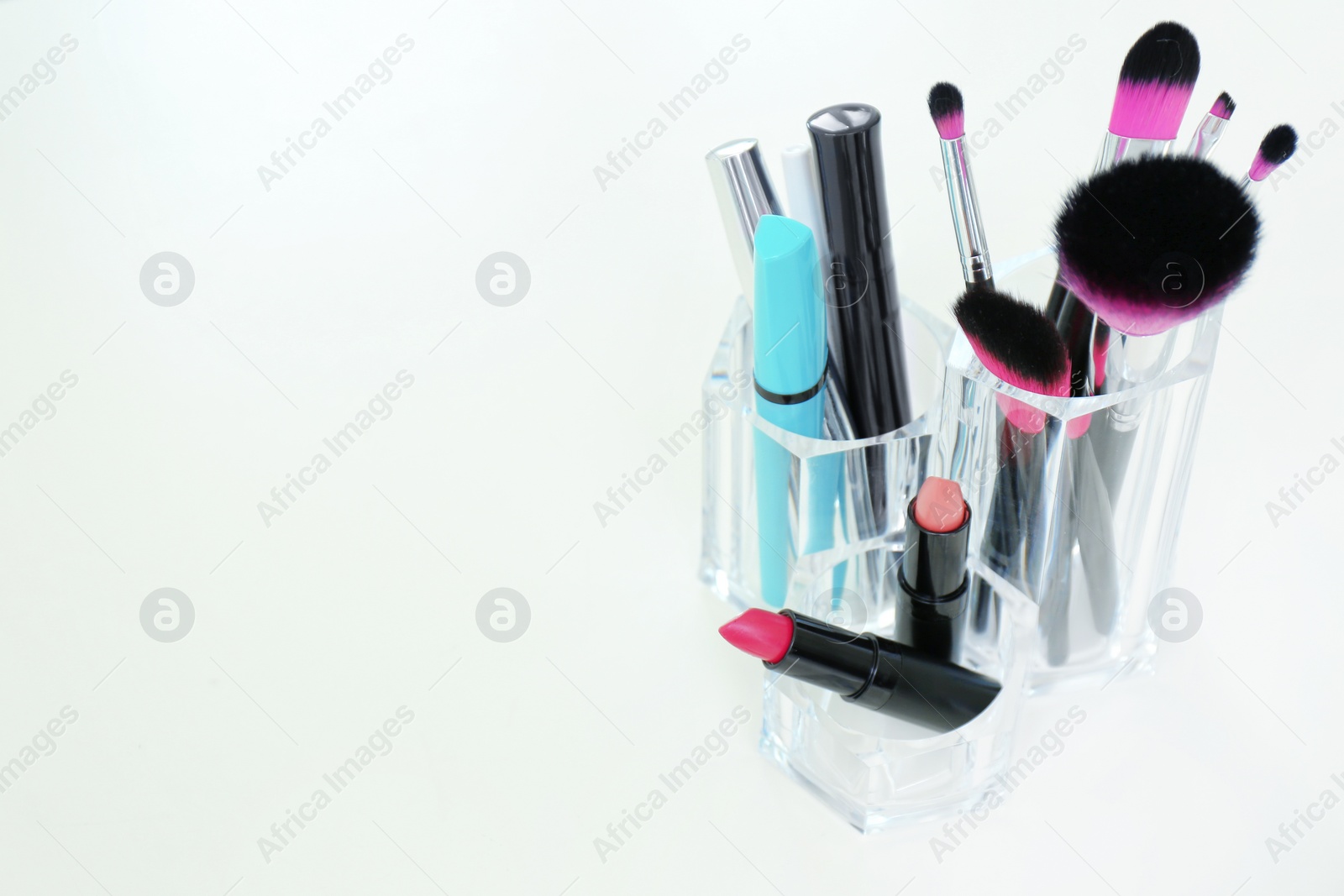 Photo of Organizer with makeup cosmetic products on light table. Space for text