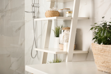 Photo of Shelving unit with toiletries in bathroom interior