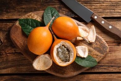 Delicious ripe granadillas on wooden table, flat lay