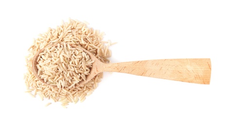 Photo of Spoon and uncooked brown rice on white background, top view