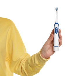 Photo of Woman holding electric toothbrush on white background, closeup