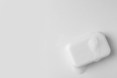 Photo of Soap with fluffy foam on white background, top view