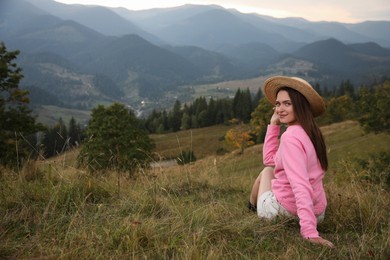 Photo of Young woman enjoying beautiful mountains landscape. Space for text