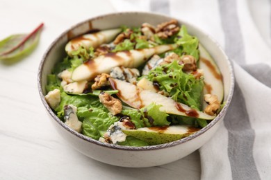 Photo of Delicious pear salad with sauce in bowl on light table, closeup