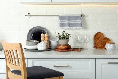 Photo of Set of clean tableware on white countertop in kitchen