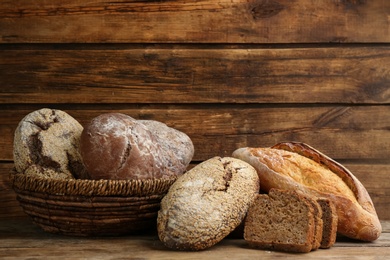 Different kinds of fresh bread on wooden table