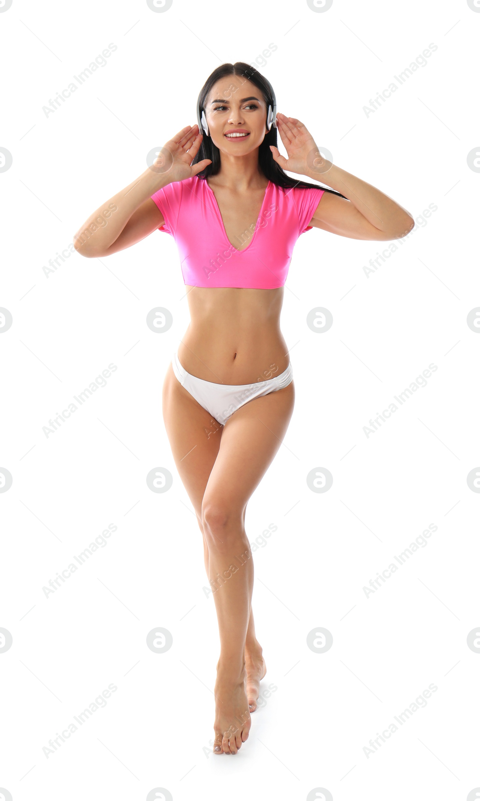 Photo of Beautiful young woman in stylish bikini with headphones on white background
