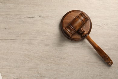 Photo of Wooden gavel on light table, top view. Space for text