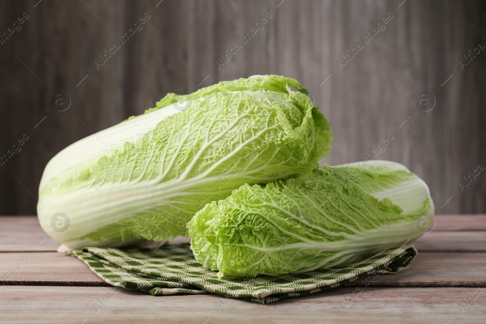 Photo of Fresh ripe Chinese cabbages on wooden table