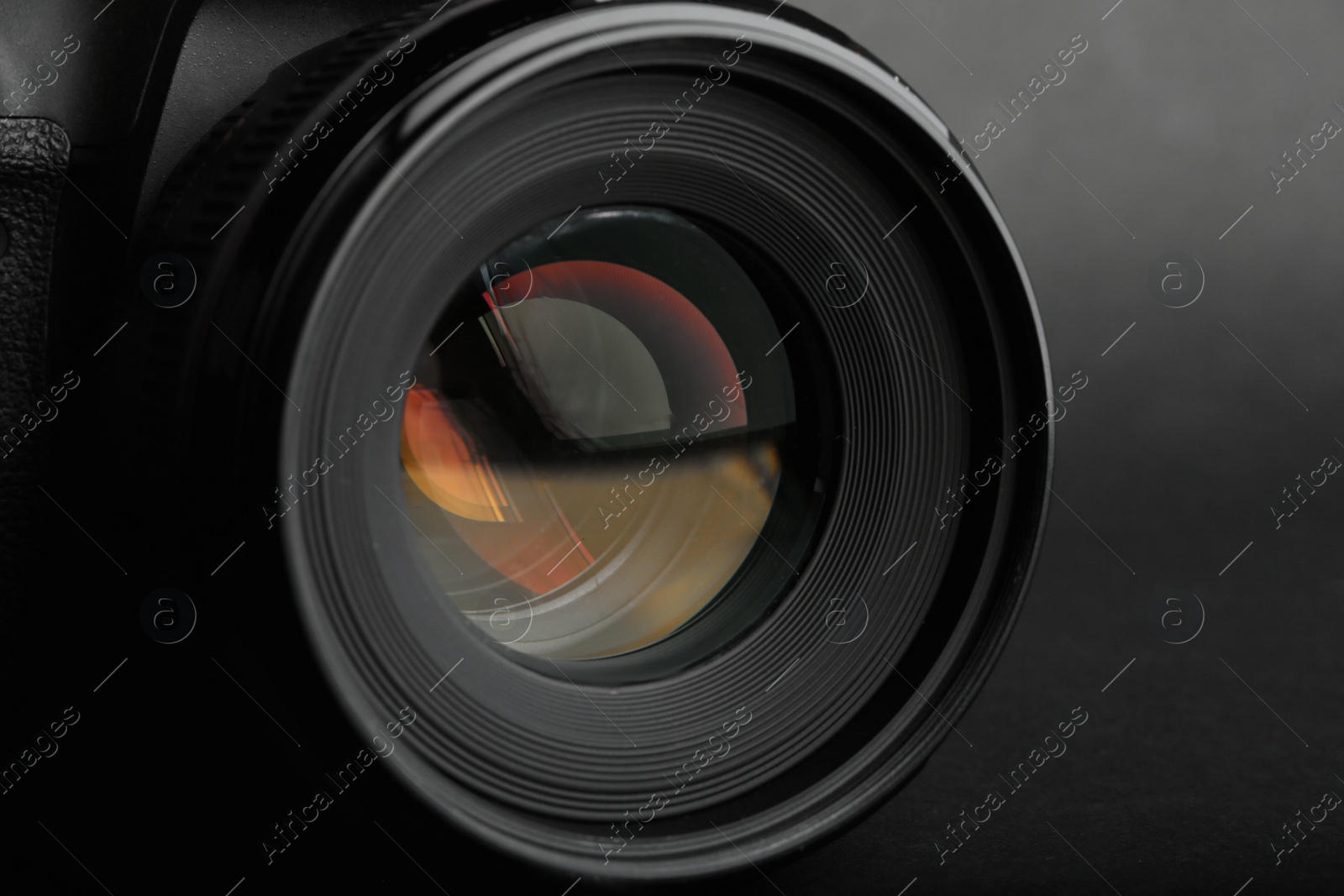 Photo of Modern camera with lens on black background, closeup