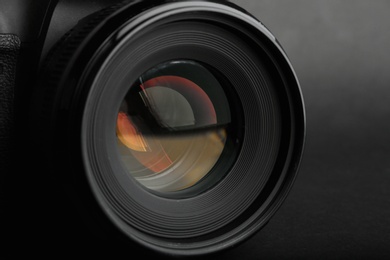 Modern camera with lens on black background, closeup