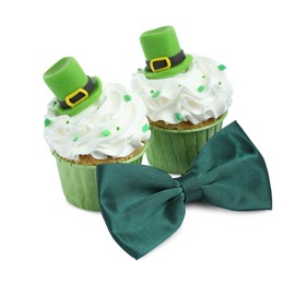 Photo of St. Patrick's day party. Tasty festively decorated cupcakes and green bow tie, isolated on white