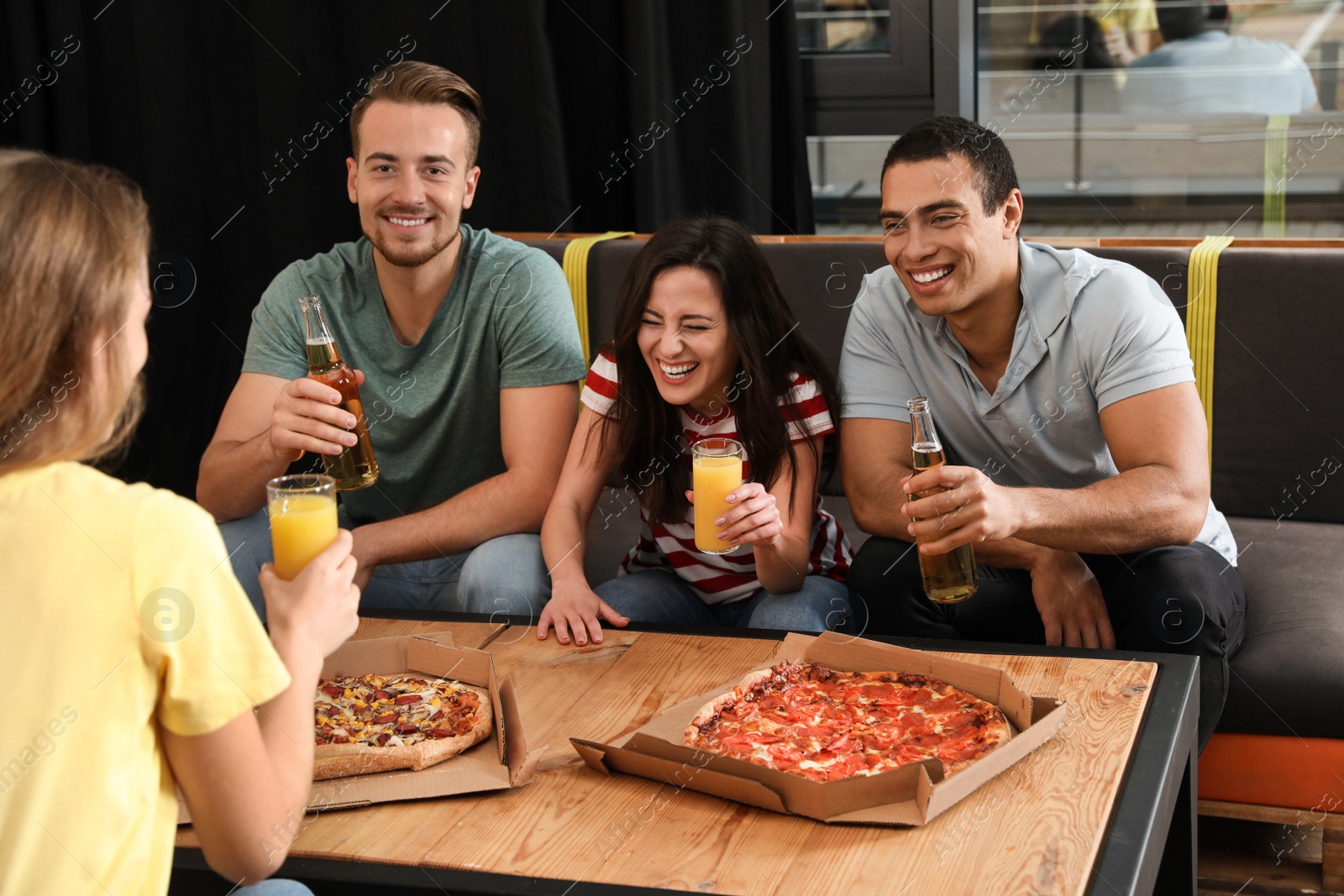 Photo of Group of friends having fun party with delicious pizza in cafe