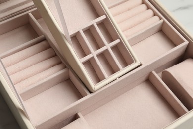 Photo of Empty beige jewelry box on table, closeup