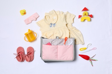 Photo of Composition with maternity bag and baby accessories on white background, top view