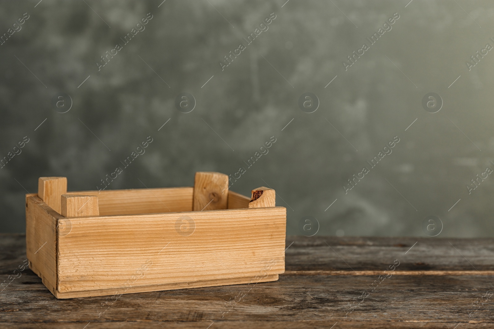 Photo of Wooden crate on table against color background. Space for text