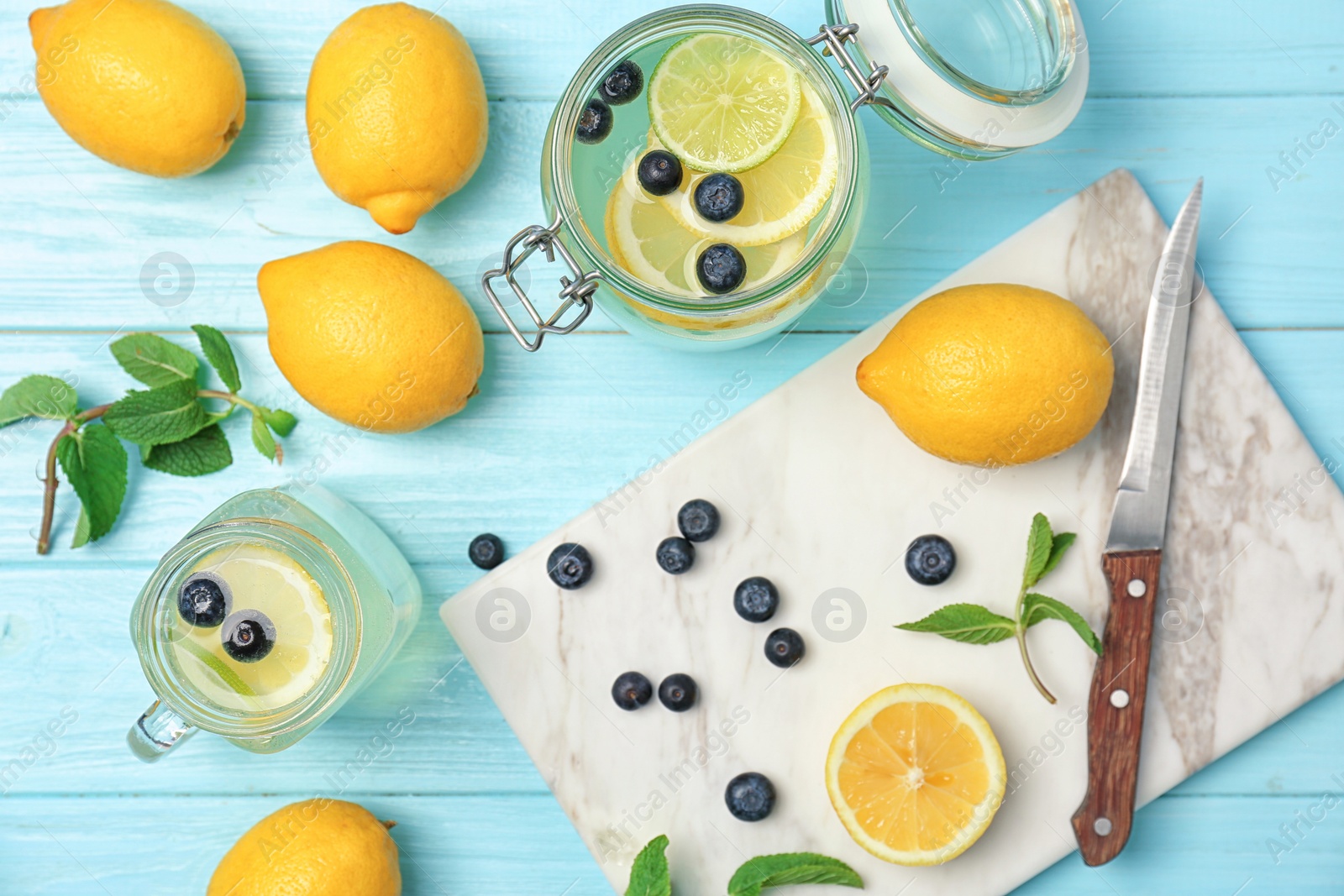 Photo of Flat lay composition with delicious natural lemonade on color background