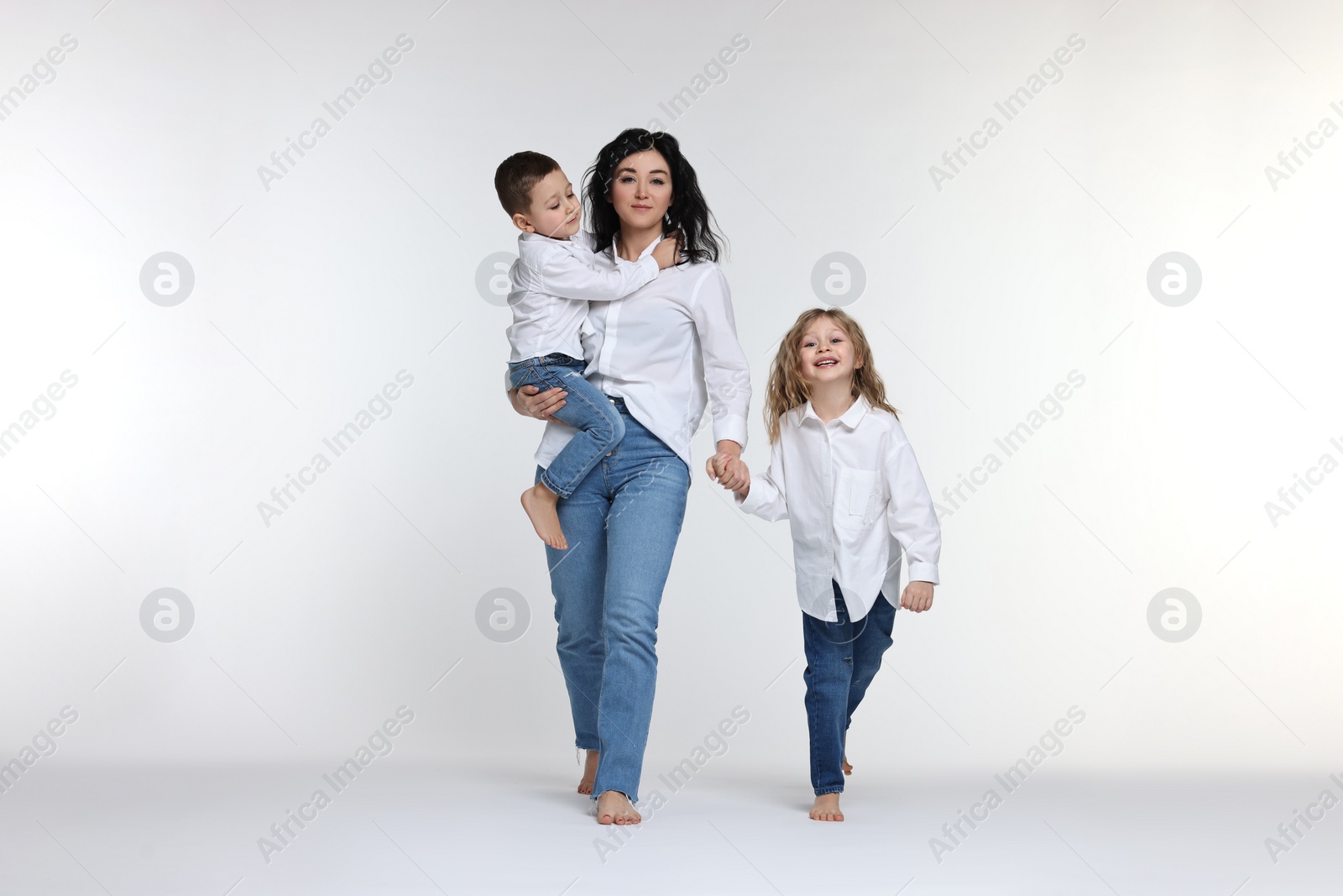 Photo of Little children with their mother on white background