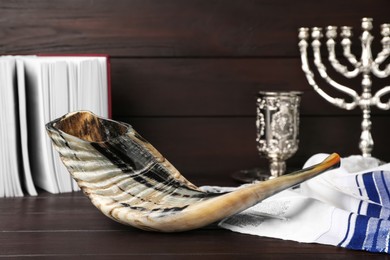 Shofar and other Rosh Hashanah holiday attributes on wooden table
