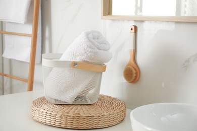 Photo of Basket with clean towel in modern bathroom interior